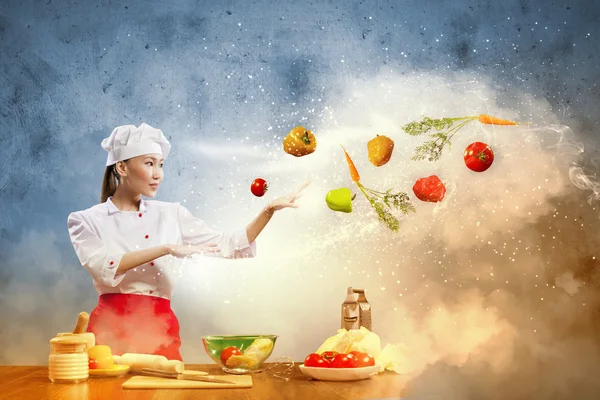 Aziatische vrouw koken met magie — Stockfoto