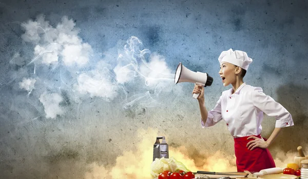 Asiática fêmea cozinhar segurando megafone — Fotografia de Stock