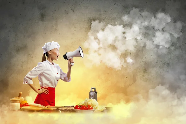 Asiática fêmea cozinhar segurando megafone — Fotografia de Stock
