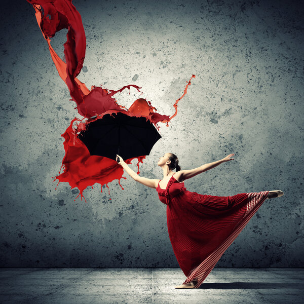 Ballet dancer in flying satin dress with umbrella under the paint