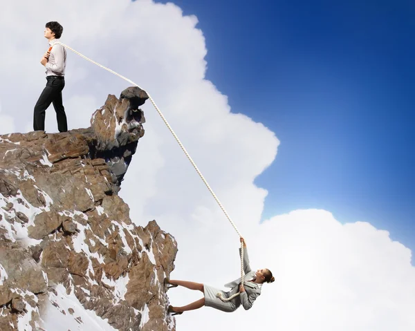 Zwei Geschäftsleute ziehen Seil auf den Berg — Stockfoto