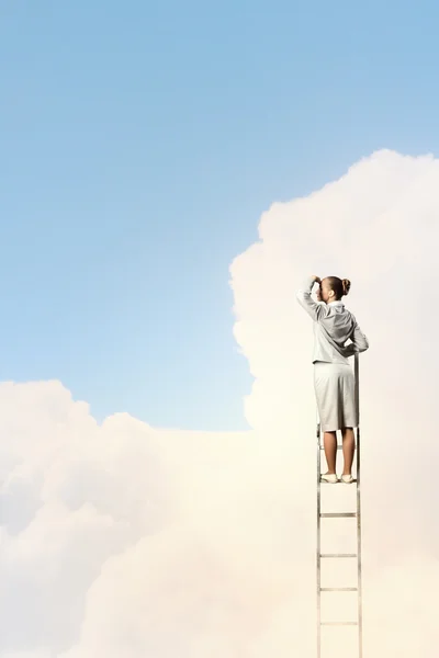 Businesswoman standing on ladder — Stock Photo, Image