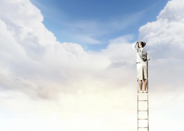 Businesswoman standing on ladder — Stock Photo, Image