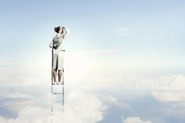 Businesswoman standing on ladder — Stock Photo, Image