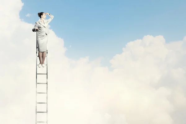 Businesswoman standing on ladder — Stock Photo, Image