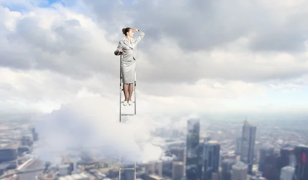 Businesswoman standing on ladder — Stock Photo, Image