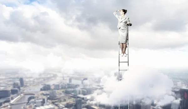 Businesswoman standing on ladder — Stock Photo, Image