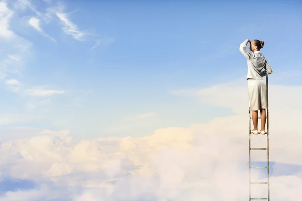 Businesswoman standing on ladder — Stock Photo, Image