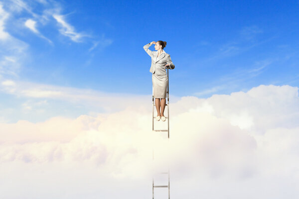 Businesswoman standing on ladder