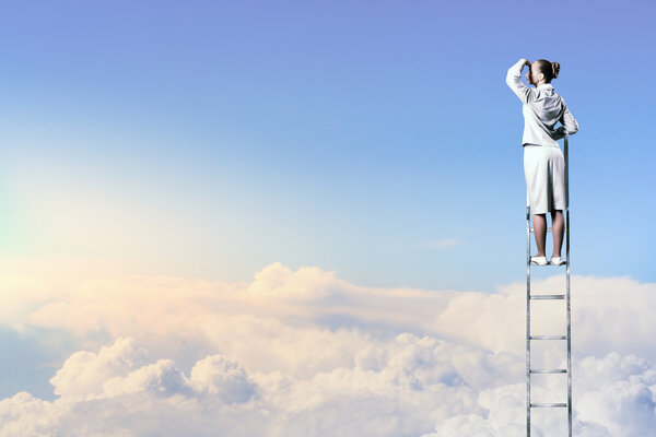 Businesswoman standing on ladder