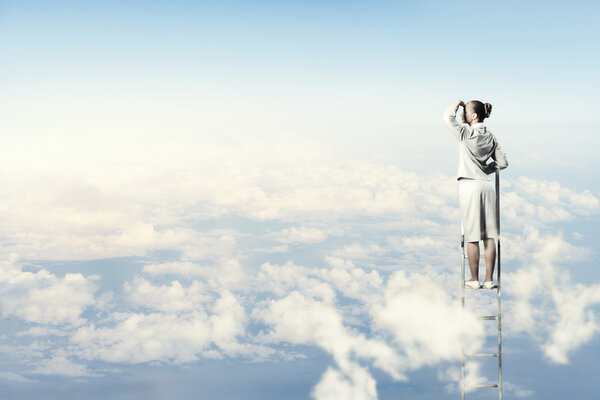 Businesswoman standing on ladder