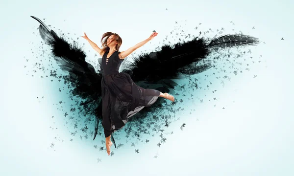 Woman floating on dark wings — Stock Photo, Image