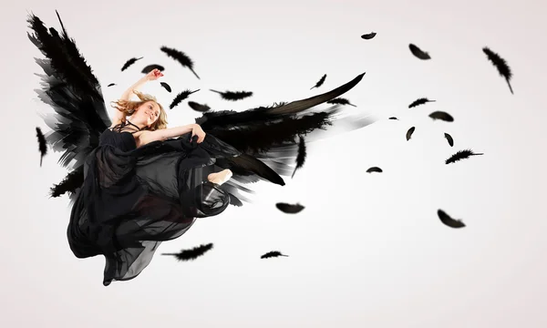 Mulher flutuando em asas escuras — Fotografia de Stock