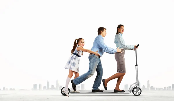 Happy family riding on scooter — Stock Photo, Image