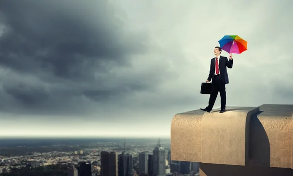 Бізнесмен з парасолькою над будівлею — стокове фото