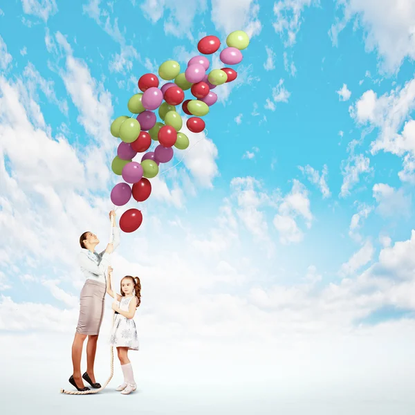 Mother and daughter with balloons — Stock Photo, Image