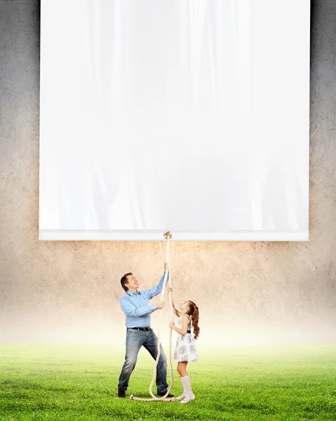 Mann und kleines Mädchen ziehen Banner — Stockfoto