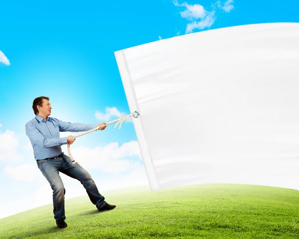 Hombre adulto tirando de la bandera en blanco — Foto de Stock