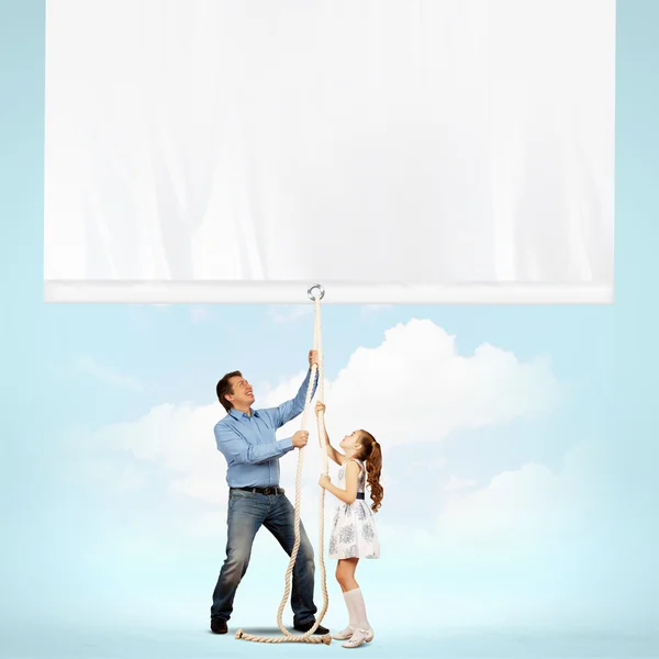 Man and little girl pulling banner — Stock Photo, Image