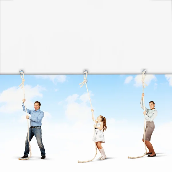 Family pulling banner — Stock Photo, Image