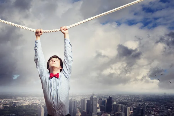 Businessman hanging on rope — Stock Photo, Image