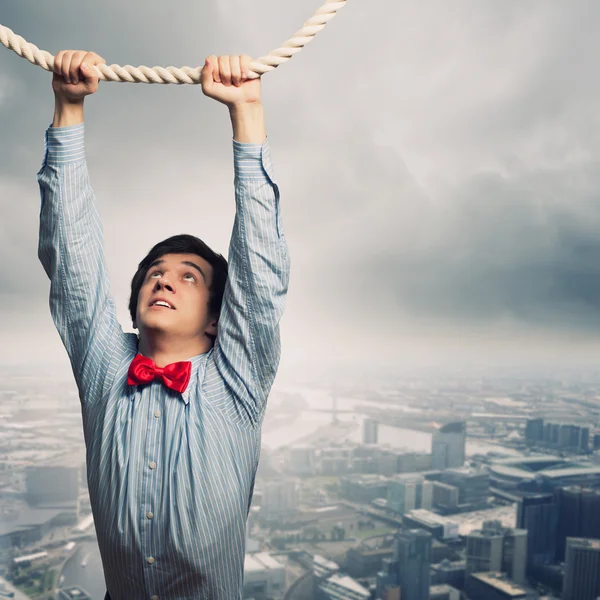 Businessman hanging on rope — Stock Photo, Image