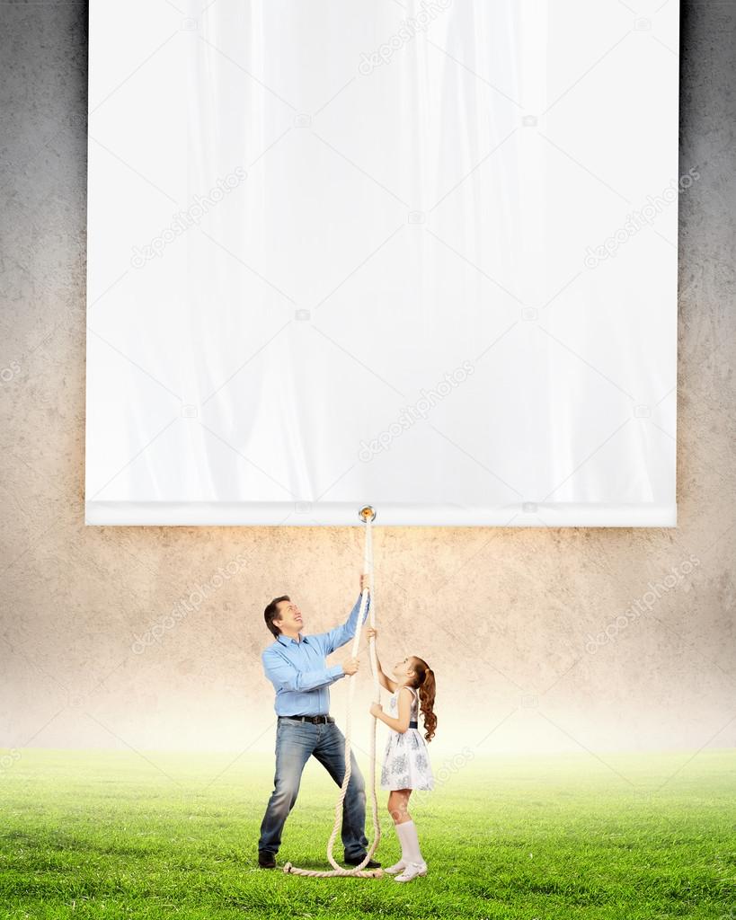 Man and little girl pulling banner