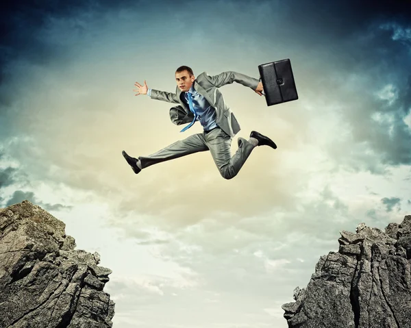 Businessman jumping over gap — Stock Photo, Image