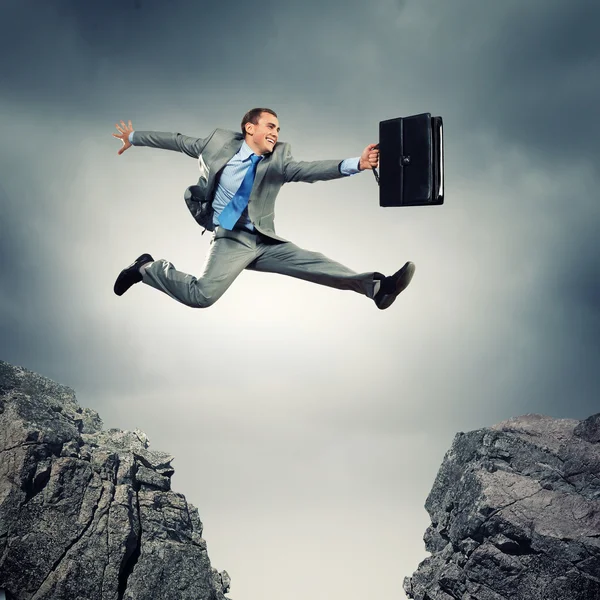 Empresario saltando sobre la brecha — Foto de Stock