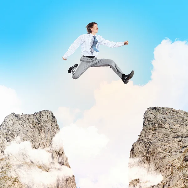 Businessman jumping over gap — Stock Photo, Image