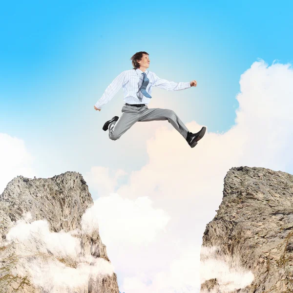 Businessman jumping over gap — Stock Photo, Image