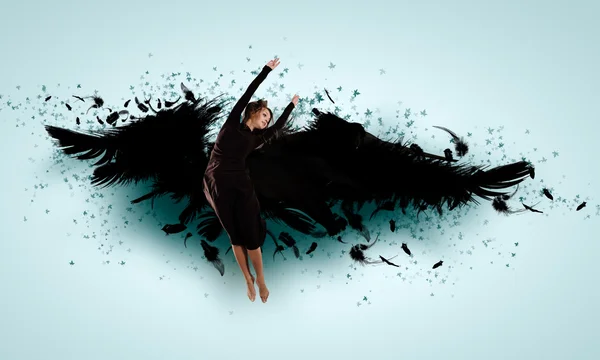 Woman floating on dark wings — Stock Photo, Image