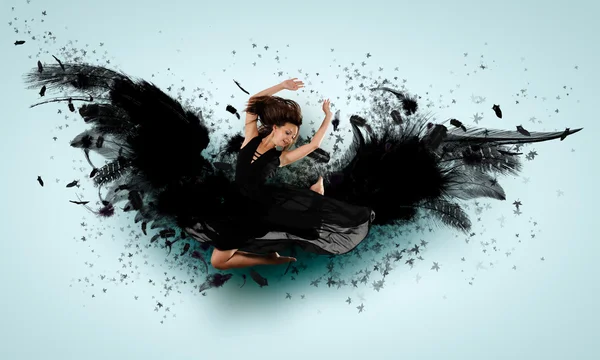 Woman floating on dark wings — Stock Photo, Image