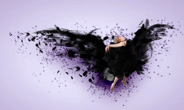 Woman floating on dark wings — Stock Photo, Image