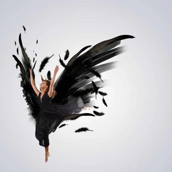 Woman floating on dark wings — Stock Photo, Image