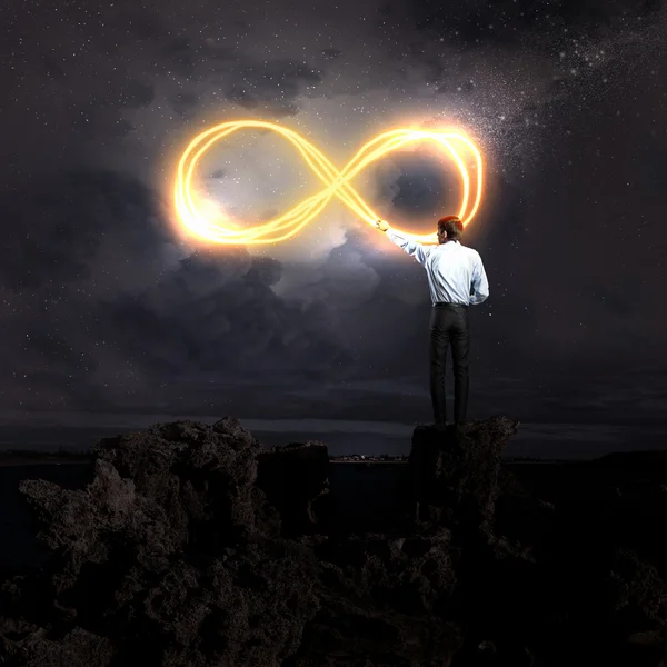 Imagen del hombre de negocios dibujando infinito signo en el cielo —  Fotos de Stock