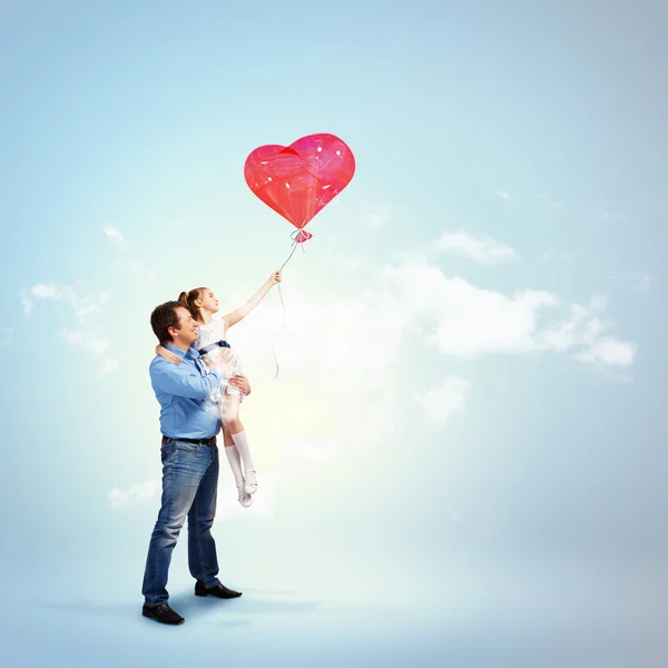 Pappa håller sin dotter och ett rött hjärta — Stockfoto