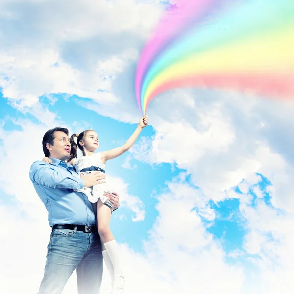 Отец держит свою дочь и радугу — стоковое фото