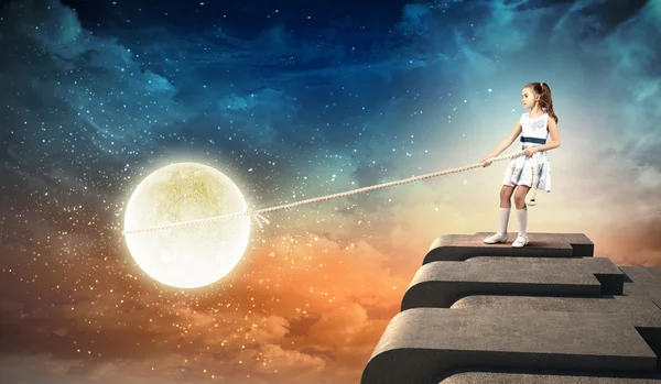 Little girl pulling moon — Stock Photo, Image
