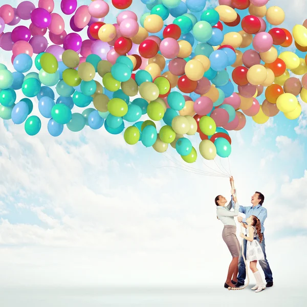 Family holding colorful balloons — Stock Photo, Image