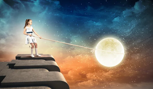 Little girl pulling moon — Stock Photo, Image