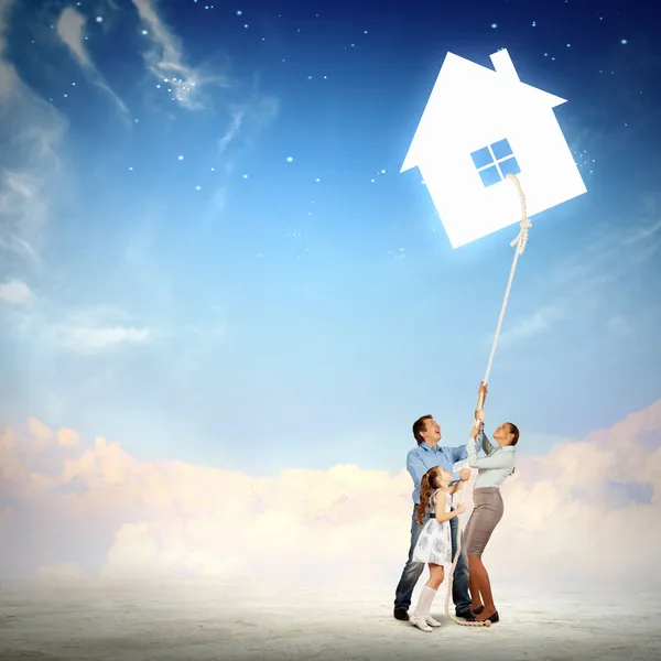 Family pulling rope with a symbol of house — Stock Photo, Image