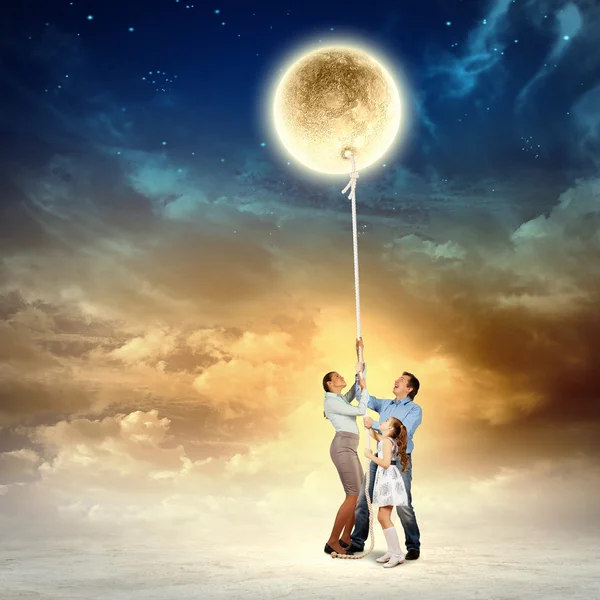 Family pulling moon — Stock Photo, Image