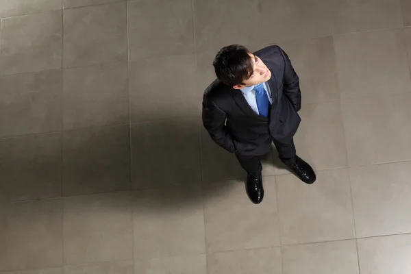 Joven hombre de negocios mirando arriba — Foto de Stock