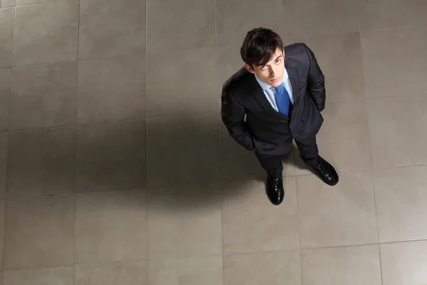 Joven hombre de negocios mirando arriba — Foto de Stock