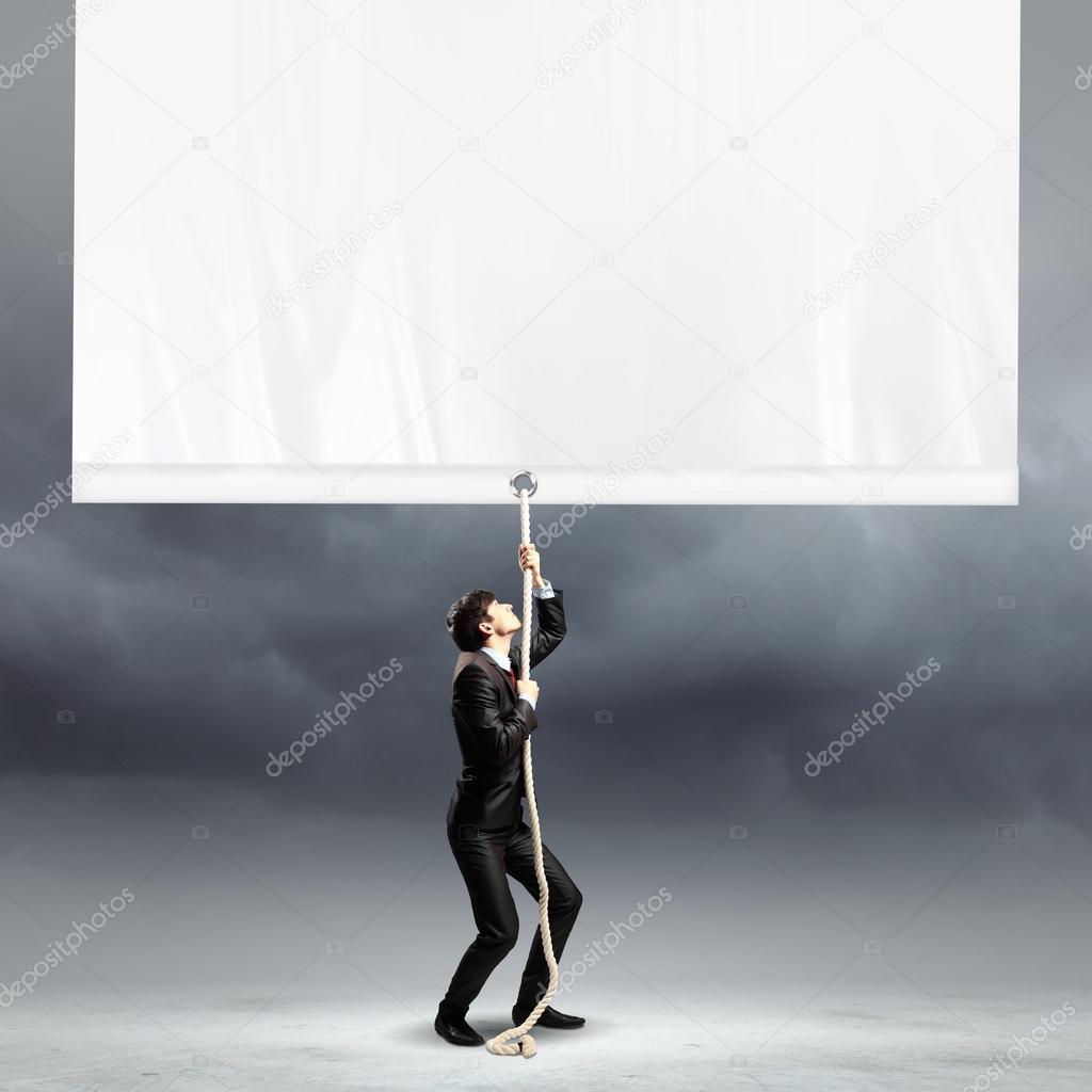 Businessman pulling blank banner