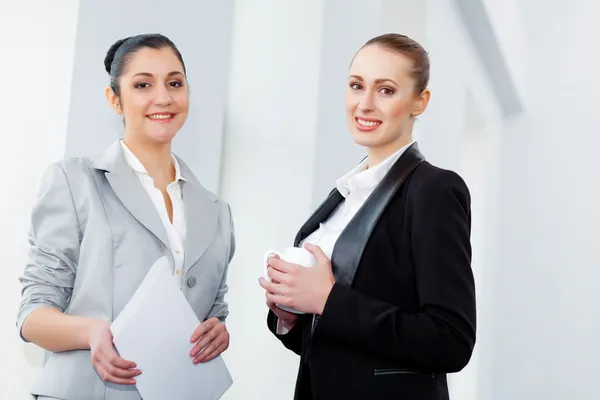 Dos atractivas mujeres de negocios sonriendo — Foto de Stock