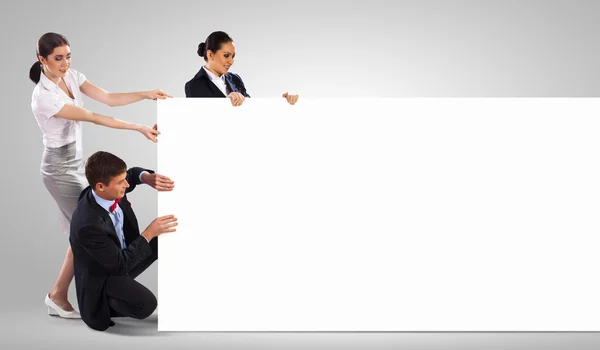 Three young holding banner — Stock Photo, Image