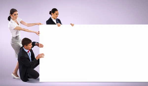 Three young holding banner — Stock Photo, Image