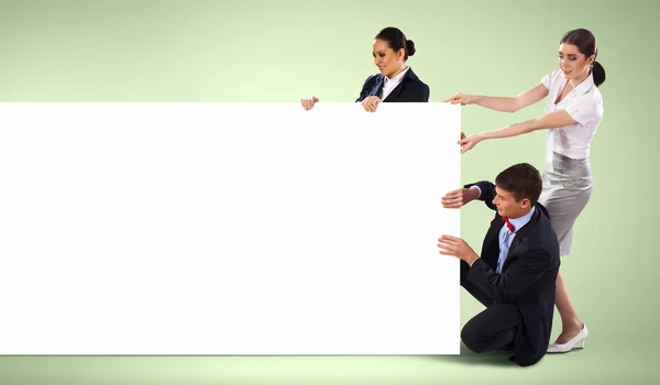 Three young holding banner — Stock Photo, Image